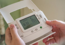 Warmth Without Waste – Smart Ways to Keep Your Home Heating Efficient Person adjusting a digital thermostat
